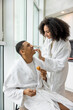 © zinkevych - Young couple in white bath robes habing breakfast and looking happy