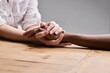 © Lerato M/peopleimages.com - Support, forgiveness and people holding hands for empathy, love and trust. Help, table and diversity with a helping hand from life coach, care of friends and showing compassion for mental health