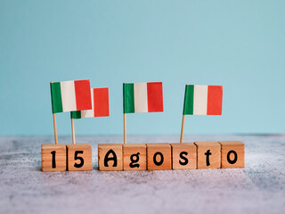 wooden cubes and miniature italy flags with the date 15 august -ferragosto .national public italian 