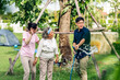 © Art_Photo - Portrait enjoy happy smiling love multi-generation asian big hug family.Senior mother with young adult woman and son water the tree green plant outdoor in park at home.insurance concept