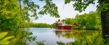 Red Boat House On The Roosevelt Lake At Roger Williams Park, Providence, Rhode Island, Vibrant Green Spring Colors In The Forest