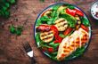 Grilled vegetables and chicken fillet salad with spinach. Paprika, zucchini, eggplant, tomatoes on rustic wooden table background, top view