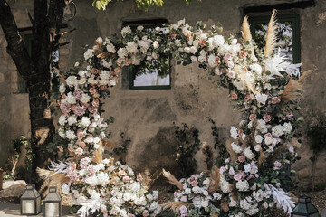 Wall Mural - Round arch decorated with flowers and greenery in the fresh air. Cute, trendy rustic decor for wedding ceremony. Floral arrangement.	