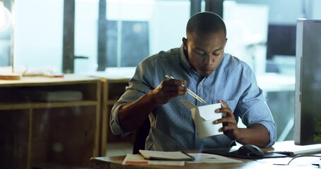 Canvas Print - Corporate, businessman and eating fast food and office at his desk with chopsticks at night. Dinner time or break period, takeout and young black male worker eat noodles at his workplace or station