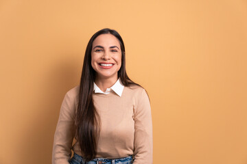 cheerful brunette young woman laughing happily in beige colors. portrait, real people concept.