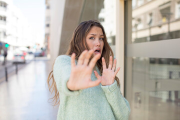 Wall Mural - pretty hispanic woman feeling terrified, backing off and screaming in horror and panic, reacting to a nightmare