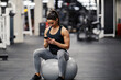 © Dusan Petkovic - A happy sportswoman is sitting on a fitness ball in a gym and checking out new fitness app.