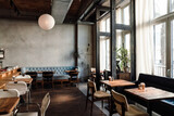 Fototapeta  - Spacious bright interior in cafe with chairs and concrete walls and wooden floor indoors