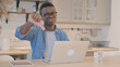 © stockbakers - Thumbs Down by Young African Man Working on Laptop