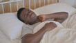 © stockbakers - Tired Young African Man with neck Pain Sleeping in Bed