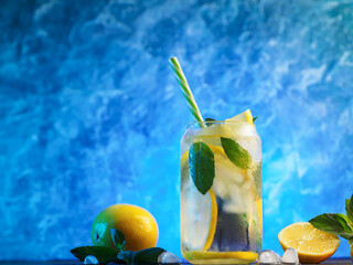 Wall Mural - summer cold lemonade with lemon and mint, blue background.
