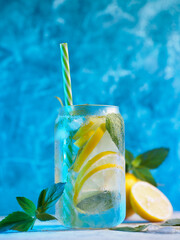 Wall Mural - summer cold lemonade with lemon and mint, blue background.