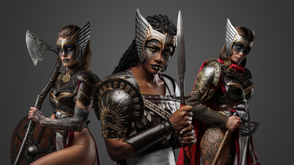 Canvas Print - Shot of three warriors women dressed in steel armors with spear and axes.