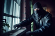 © MVProductions - Burglar breaking into a house at night. Person in a black hoodie and mask breaking into a house. Criminal issues concept. Generative AI