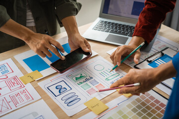 Group of asian creative team programing designers participate in all phases of the UX design.