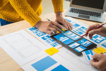 Wall Mural - group of asian creative team programing designers participate in all phases of the ux design.
