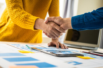 Wall Mural - shaking hands, group of asian creative team programing designers participate in all phases of the ux