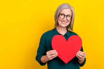 Sticker - Photo of attractive positive lady hands hold heart card look empty space isolated on yellow color background