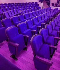 Wall Mural - An empty modern cinema or conference room with rows of chairs, neon tinting