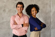 © Prostock-studio - Two successful multicultural businesspeople standing back to back, arms crossed