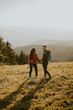 © BGStock72 - Smiling couple walking with backpacks over green hills