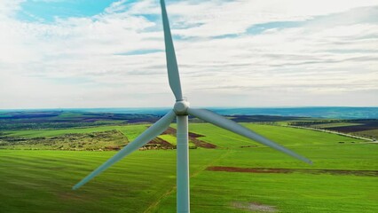 Wall Mural - Aerial drone view of a working wind turbine in Moldova. Green fields around