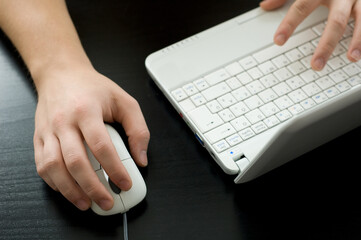 Using a laptop (shallow DOF, right hand is in focus)