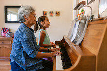 Woman Plays Piano While Grandchild Sings At Home