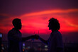 © Jovo Jovanovic/Stocksy - Silhouette of two friends toasting drinks glass on rooftop at sunset