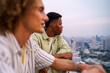 © Jovo Jovanovic/Stocksy - Two young men admiring cityscape from rooftop