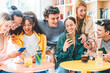 © Nicolas Micolani - Group of diverse friends watching video and using mobile phone at cocktail bar- Happy young people having fun together drinking fancy cocktails sitting at table bar enjoying summer holiday-Lifestyle