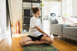 © Diego Martin/Stocksy - Female practising yoga at home