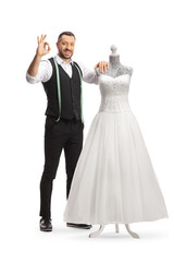 Canvas Print - Tailor standing next to a bridal gown on a doll mannequin and gesturing great