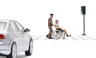 Poster - Elderly man pushing a young woman in a wheelchair at a pedestrian crossing