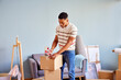 © ALTO IMAGES/Stocksy - African American male in casual clothes packing carton box with tape