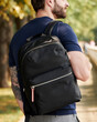 © Elena Kharichkina/Stocksy - Man with a backpack on his shoulder close-up