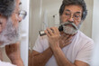 © Jordana Sheara/Stocksy - Retired latin man shaving in his bathroom