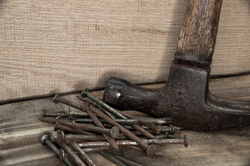 close up of hammer with nails on wood with black background with reduced vibrance, grungy, old, antique, vintage