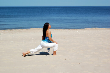 Canvas Print - attractive brunette woman doing exercise on the beach