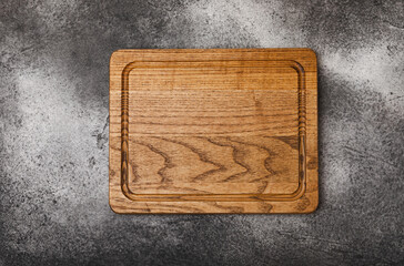 Wall Mural - Cutting board on gray kitchen table texture background. Recipe. Kitchenware. Empty modern wooden cutting board. MOCKUP. Place for text. Place to copy.