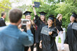 © Sean Locke/Stocksy - Grad: Father Takes Photo Of Girl With Friends