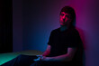 © Ibai Acevedo/Stocksy - Neon light portrait of young man resting in dark room