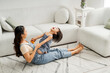 © Marc Tran/Stocksy - Cute small girl playing with mother in home living room