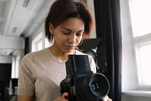 Young Female Photographer Working In Studio