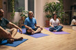 © Pedro Merino/Stocksy - Group of people receiving a yoga class