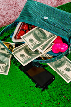 Fake Dollar Bills And Other Items Out From A Green Purse