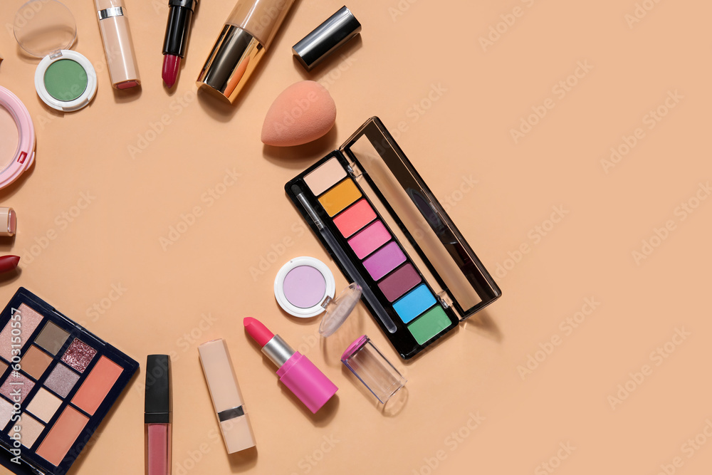 Frame made of decorative cosmetics with lipsticks on beige background