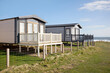 © James Ross/Stocksy - Static caravans by the sea