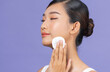 © Marc Tran/Stocksy - Studio shot of beautiful young woman using cotton pad