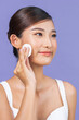 © Marc Tran/Stocksy - Portrait of young beautiful woman with cotton pads cleaning her face